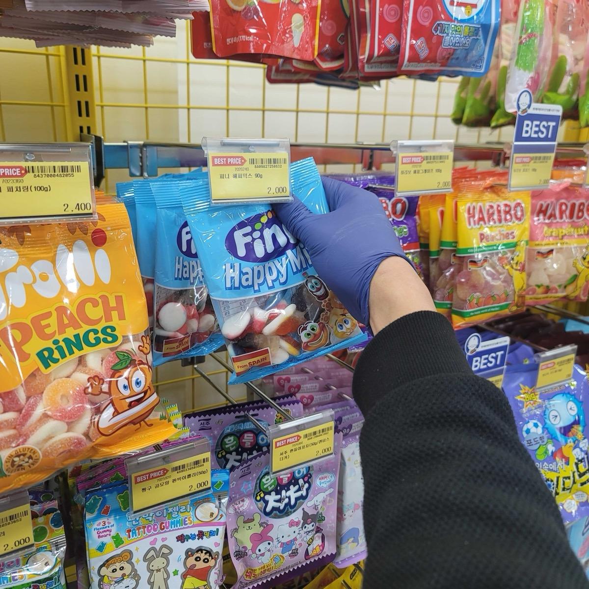 크루가 문구점 진열대 상품을 앞으로 정리하는 모습