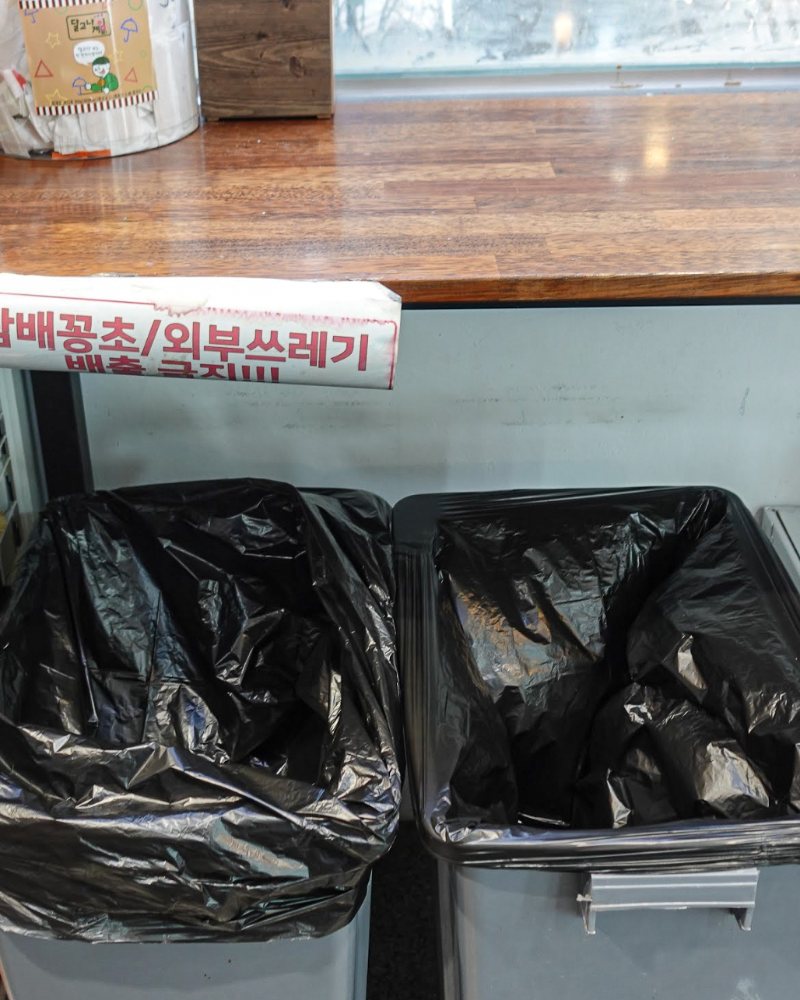 관리 후: 봉투를 새로 끼우고 정리한 쓰레기통과 계산대