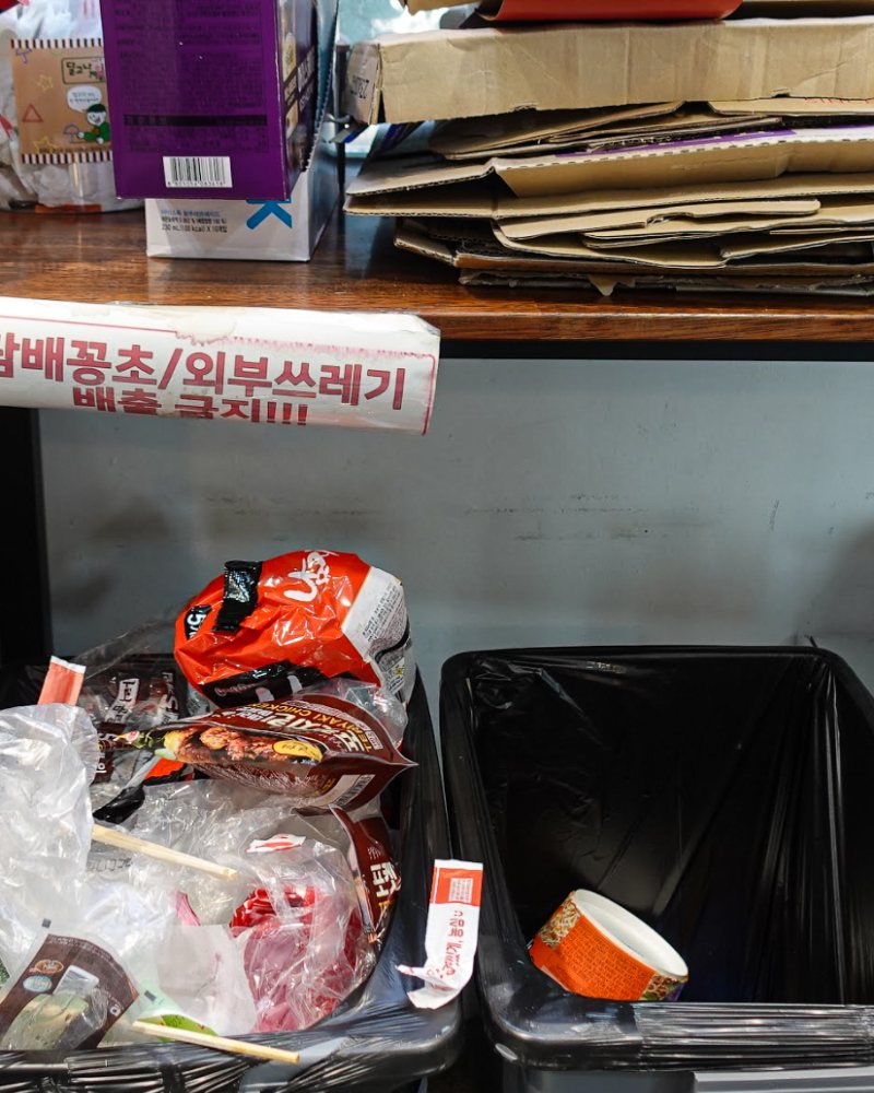 관리 전: 쓰레기가 넘치고 박스가 쌓인 계산대 아래